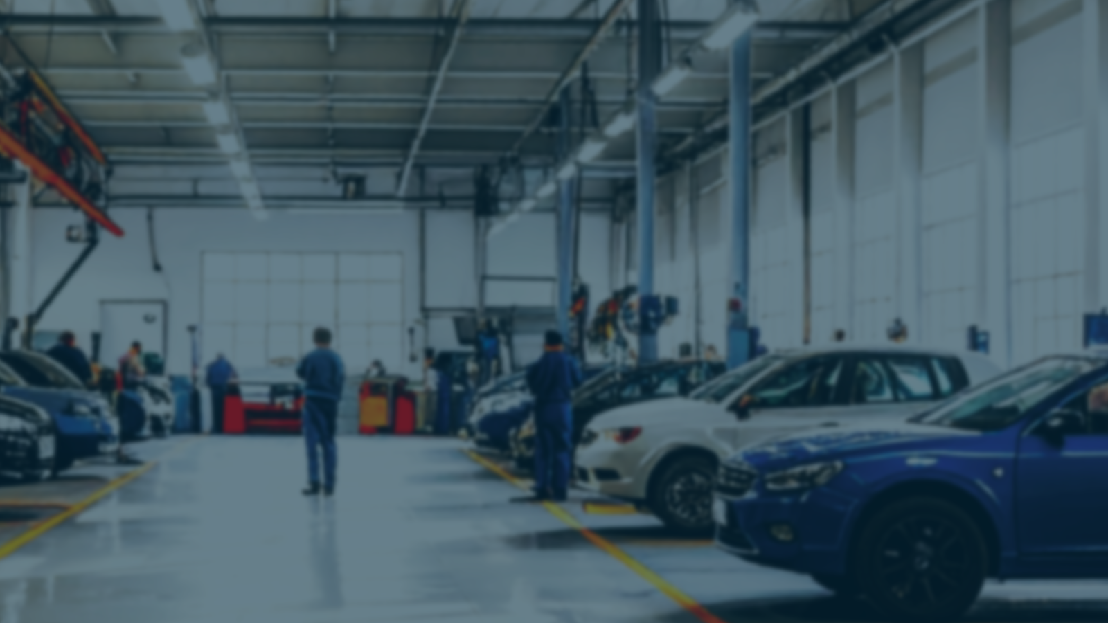 Busy automotive workshop with multiple technicians working in Cardiff